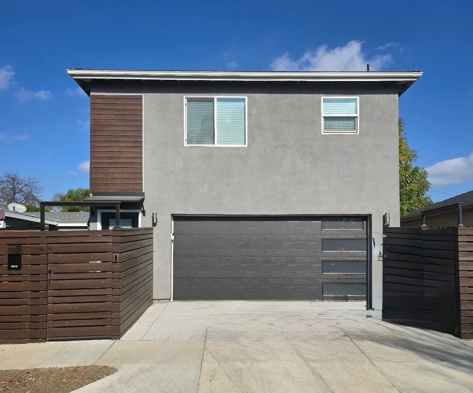 After construction: contemporary two-story building with garage and wood accents